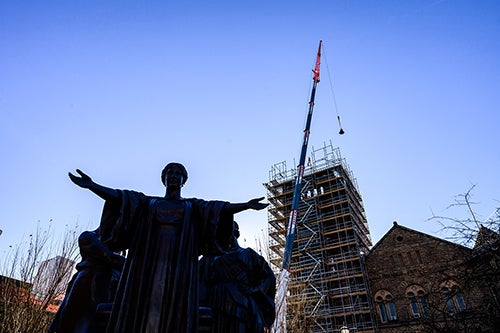 A bell hangs behind Alma Mater