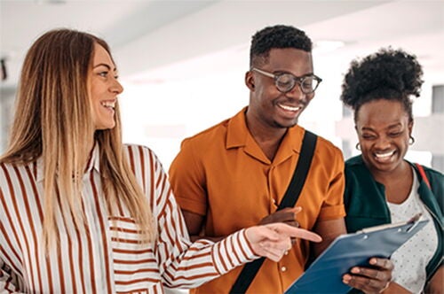 People smiling and pointing at a photo