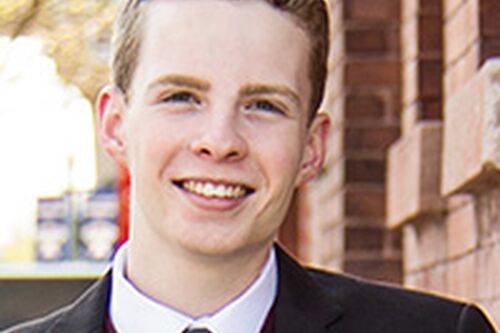 LAS student poses for photo in black suit and blue tie